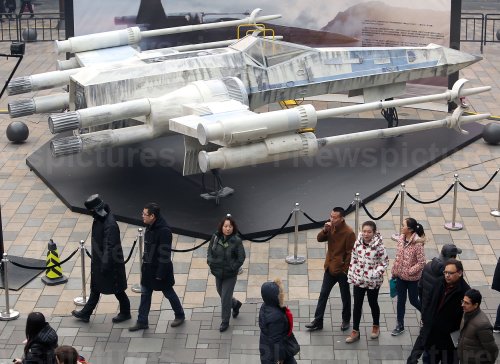 Chinese walk past a Lego X-Wing fighter in Beijing